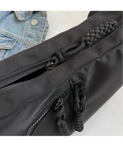 Detail von mattschwarzen Beschlägen und Nylon-Reißverschluss mit geflochtener Kordel am Bag