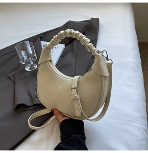 Detail of cream beige crescent bag with scrunchie handle and lychee leather texture