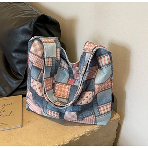 Detail of vintage patchwork canvas tote bag featuring denim textures and floral patterns