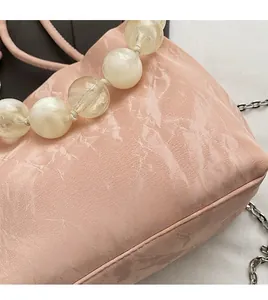 Detail of pink marble-textured bag with pearly bead handle and silver metal chain
