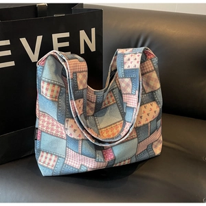 Detailed patchwork texture on denim tote bag with floral and plaid fabric panels