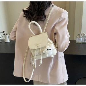 Detail view of cream mini backpack with drawstring closure and metal triangle logo plaque