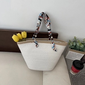 Woven straw tote bag with silk scarf handle and wooden beads for beach vacations