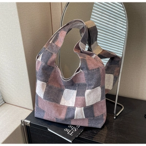Detail of vintage patchwork canvas tote bag showing textured panels and wide strap