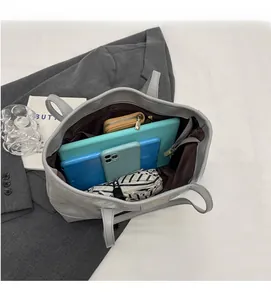 Detailed view of the spacious inner compartment of the gray tote bag with essentials