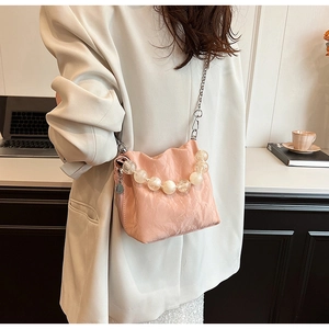 Detailed close-up of pink pleated mini bucket bag with clear bead handle and silver chain
