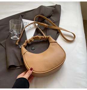 Detail of lychee pattern leather crescent bag with ruched handle and silver hardware