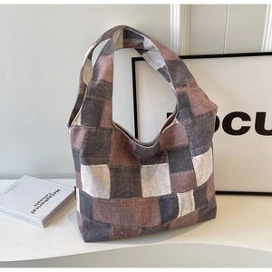 Detail view of frayed edge patchwork canvas tote bag showing earthy tones and texture