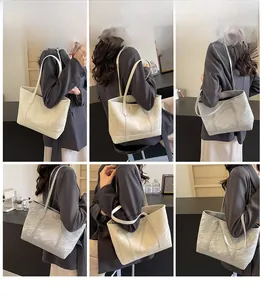 Detail of large textured tote bag in white and grey showing pleated surface and metal plate