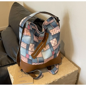 Detail view of vintage patchwork canvas backpack with denim, floral patterns and leather straps