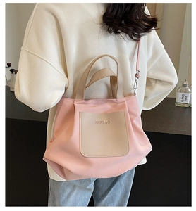 Gros plan du cabas en nylon rose avec poche en cuir beige et bandoulière réglable