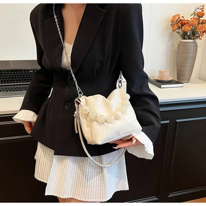 Detail of white leather bucket bag with large clear beads handle and silver chain strap