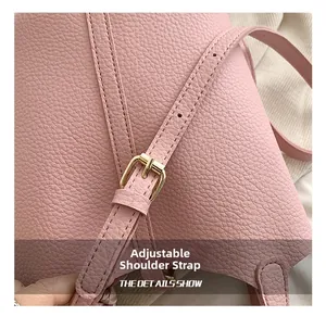 Detail of adjustable pink lychee leather strap with gold buckle on a bucket bag