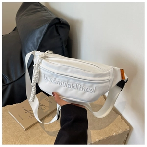 Close-up of white crossbody bag with 3D embroidery and decorative woven zipper pull