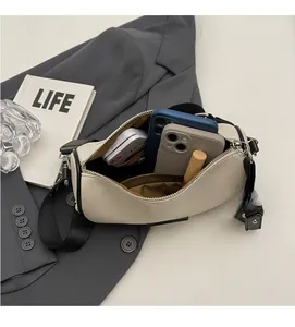 Detailed view of cream cylinder bag interior showing capacity for phone and cosmetics