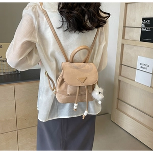 Detailed back view of a mini apricot backpack with plush charm and metal ring design