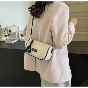 Litchi pattern leather cylinder bag with wide shoulder strap in beige and black trim
