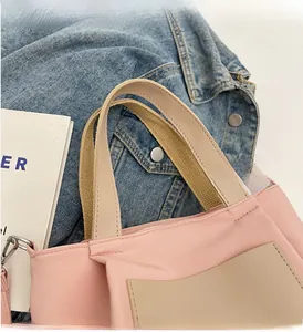 Détail d'un sac cabas en nylon rose avec poche en cuir beige et logo KFRBAO