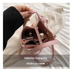 Top view of pink leather bucket bag interior with silk scarf and gold hardware detail