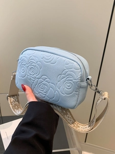 Sky blue embossed leather crossbody bag with rose patterns and wide geometric strap
