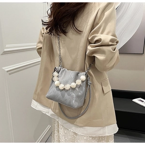 Detail of marble pattern shoulder bag with oversized pearl handle and silver chain