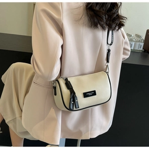 Detail of cream white leather boston bag with wide strap and tassel zipper on model