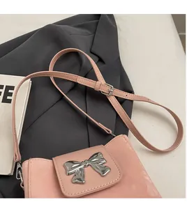 Close-up of pink bucket bag with silver bow buckle and adjustable smooth shoulder strap