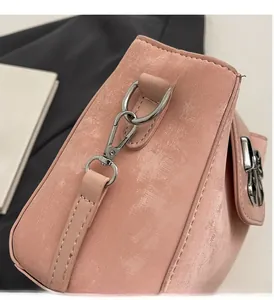 Detail of pink glossy bucket bag showing silver metal hardware and patent leather texture