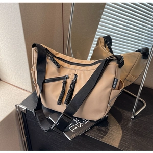 Detailansicht der khakifarbenen Nylon-Umhängetasche mit Multi-Taschen und Reißverschlüssen
