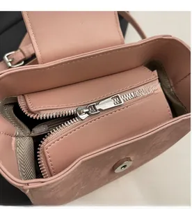Detail of smooth silver zipper and magnetic snap closure on a dusty rose bucket bag
