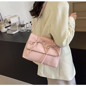 Détail du sac à bandoulière plissé rose clair avec nœuds décoratifs et cuir PU mat élégant