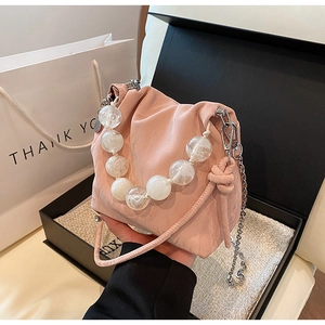 Detailed close-up of pink pleated bucket bag featuring elegant pearl bead handle