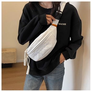Close-up of white crossbody fanny pack with embossed lettering and black buckle strap