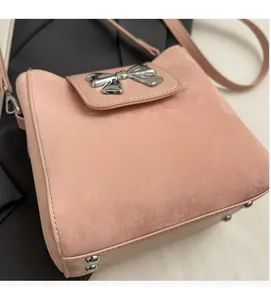 Detailed macro view of pink microfiber bucket bag with silver bow buckle and rivets