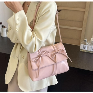 Détail du sac bandoulière rose plissé avec nœuds et texture en cuir PU de qualité