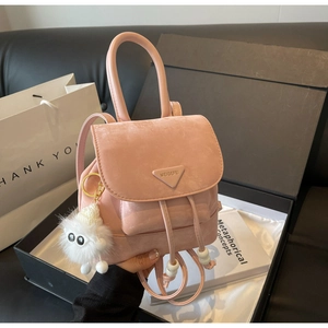 Detail of pink mini backpack with plush sheep charm inside a premium black gift box
