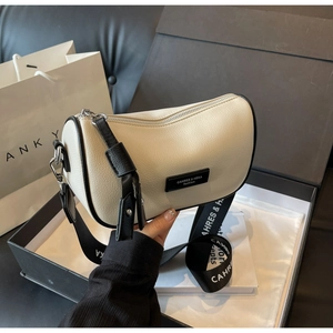 Detail of cream pebbled leather crossbody bag with wide logo strap in luxury gift box