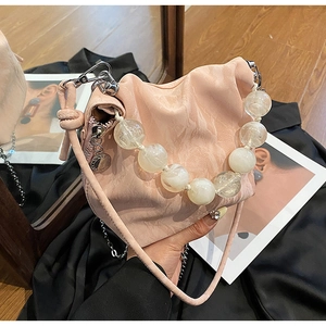 Detail of pink pleated bucket bag with oversized translucent beaded handle and silver hardware