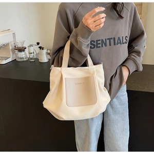 Détail d'un sac cabas en nylon beige avec poche en cuir dans un cadre de café cosy