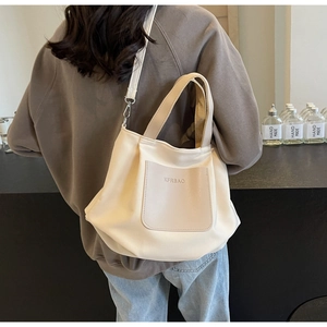 Détail du sac fourre-tout en nylon blanc cassé avec poche embossée et bandoulière amovible