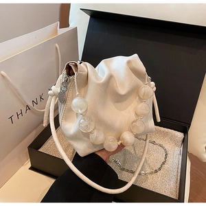 Chic cream-colored pleated bucket bag with large translucent beaded handle and gift box