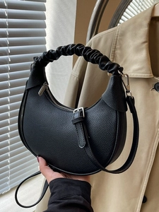 Minimalist black crescent dumpling bag with pleated handle and pebbled leather texture