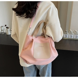 Vue détaillée du cabas en nylon rose avec poche beige et bandoulière amovible