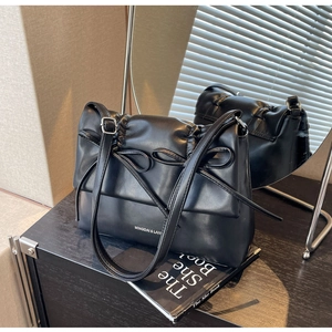 Vue détaillée du sac bandoulière plissé noir avec double nœud et boucle de sangle argent