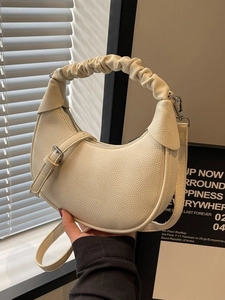 Minimalist beige dumpling shoulder bag in premium lychee leather with pleated handle