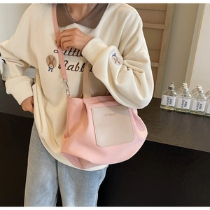 Vue détaillée du cabas en nylon rose avec patch logo cousu et bandoulière pratique