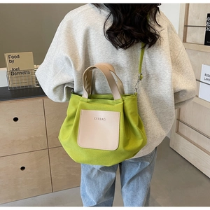 Détail du sac cabas en nylon vert herbe avec poche en cuir ivoire et bandoulière