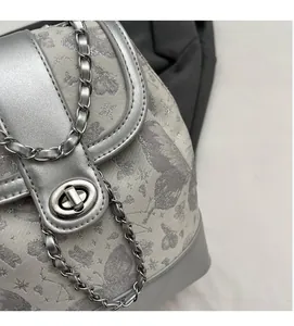 Close-up of butterfly print fabric and silver metal twist lock on a small backpack