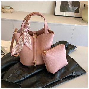 Detailed macro of pink lychee leather bucket bag with silk scarf and gold lock hardware