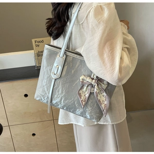 Detail of silver metallic tote bag with wrinkled texture and fashion silk scarf bow